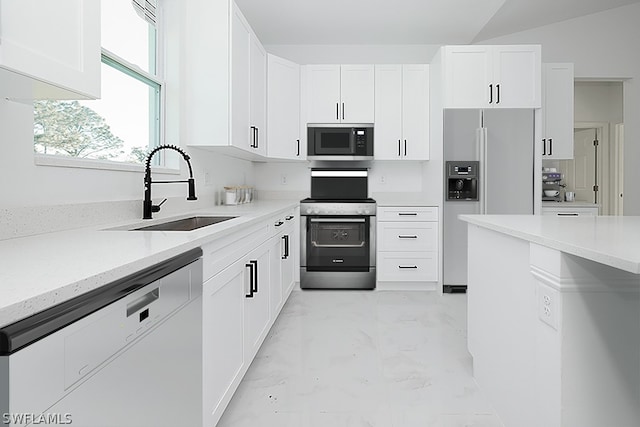 kitchen with sink, white cabinets, light tile patterned floors, and stainless steel appliances