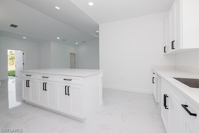 kitchen featuring light tile patterned flooring, white cabinetry, and sink