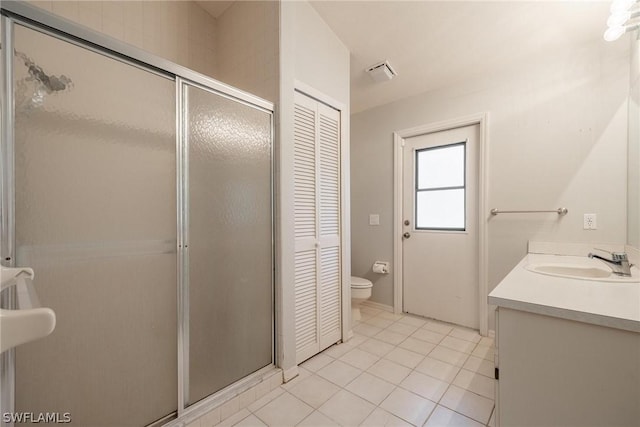 bathroom with tile patterned floors, vanity, toilet, and an enclosed shower