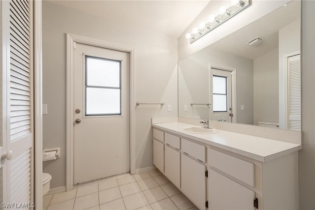 bathroom featuring a wealth of natural light, vanity, tile patterned floors, and toilet