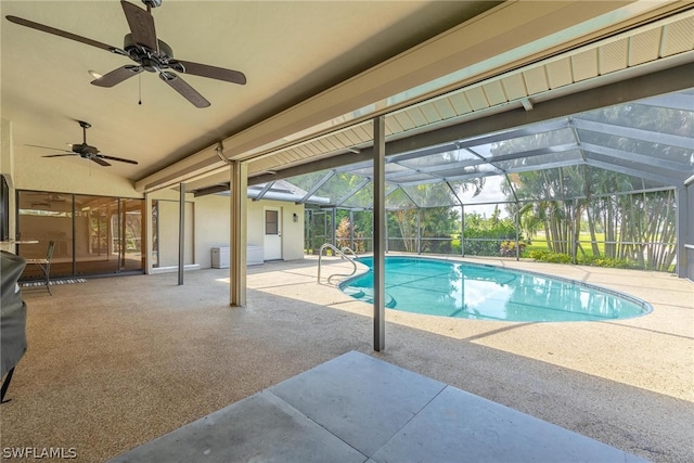 view of swimming pool with a patio, ceiling fan, and glass enclosure