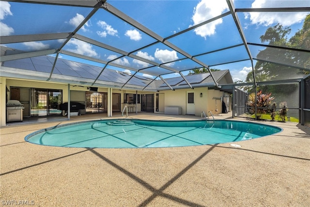 view of pool with area for grilling, glass enclosure, and a patio area