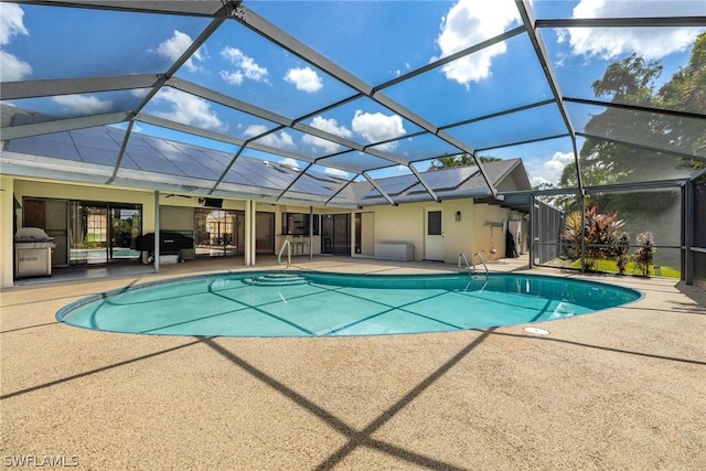 view of pool with a patio area and glass enclosure