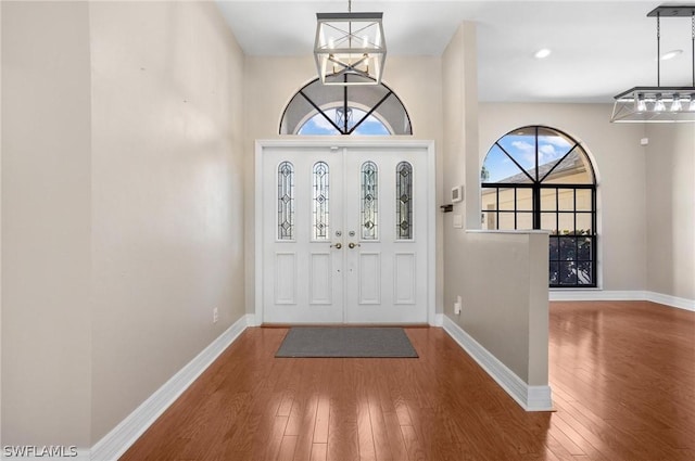 entrance foyer featuring hardwood / wood-style floors and a chandelier