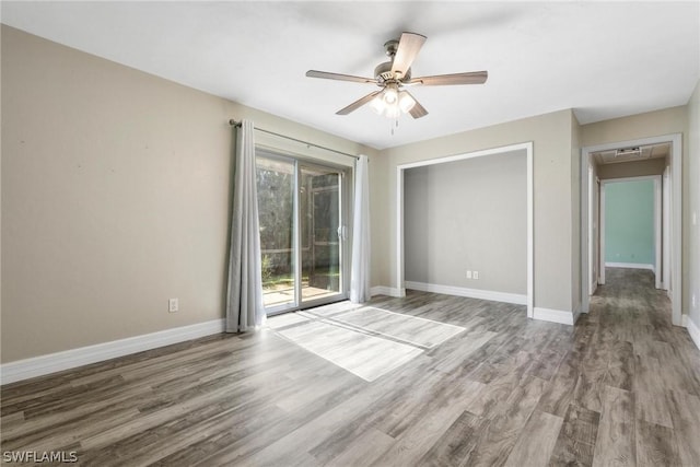 empty room with ceiling fan and hardwood / wood-style floors