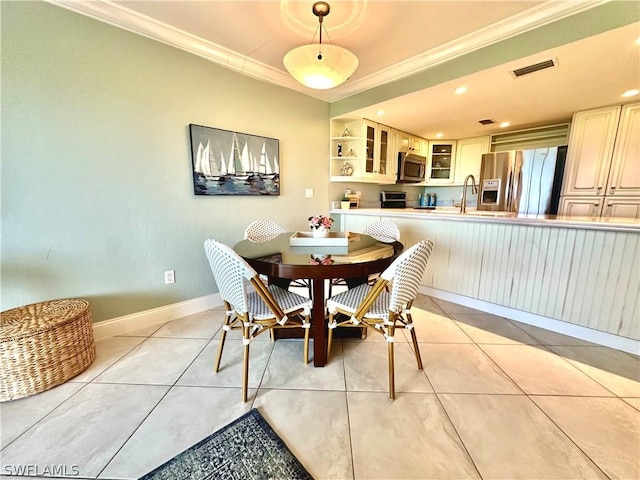 dining area with sink, crown molding, and light tile patterned flooring