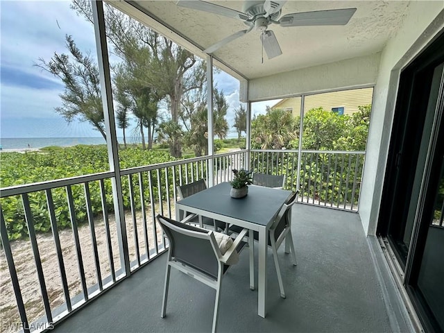 sunroom / solarium featuring ceiling fan and a water view