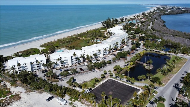 drone / aerial view featuring a beach view and a water view