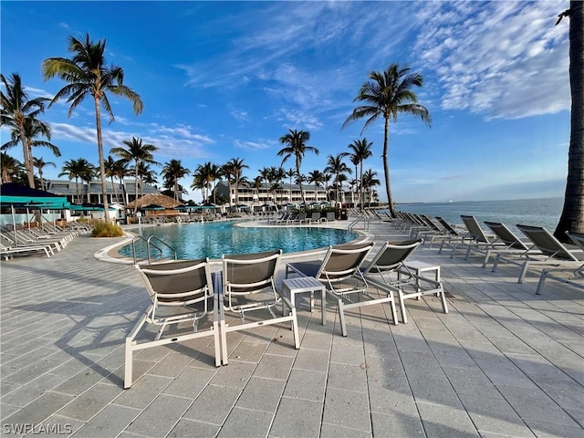 view of pool featuring a patio and a water view