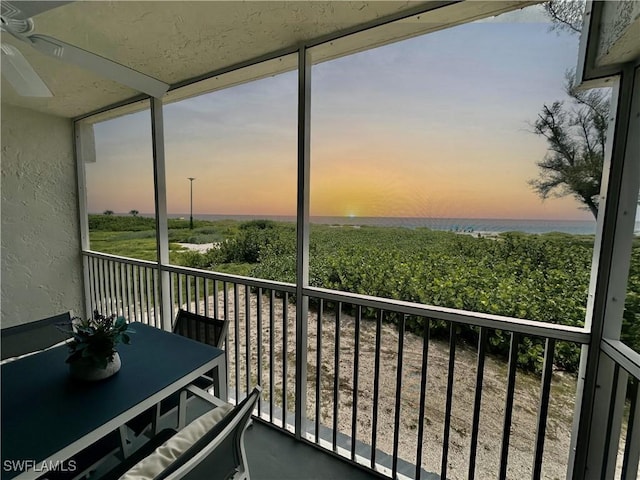 balcony at dusk featuring ceiling fan