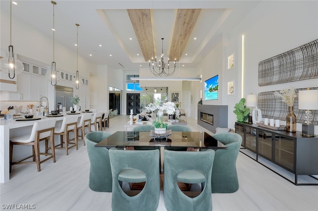 dining area with a raised ceiling and a high ceiling