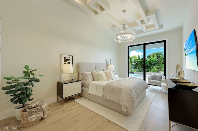 bedroom with a towering ceiling, coffered ceiling, light wood-type flooring, and access to outside