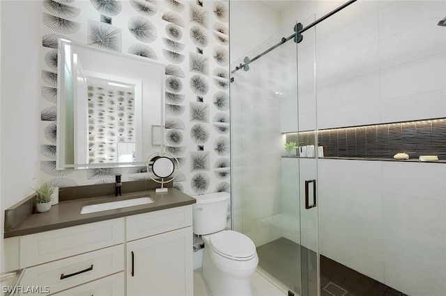 bathroom featuring toilet, a stall shower, and vanity