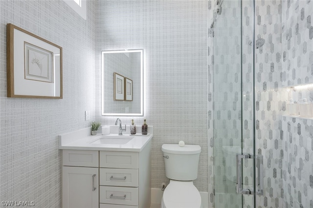 bathroom featuring vanity, a shower stall, and toilet