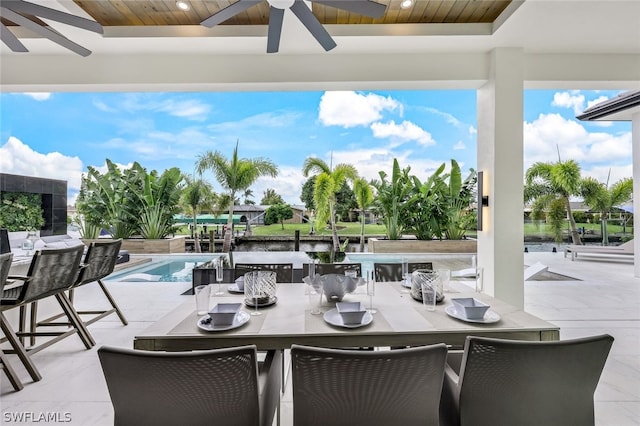 view of patio / terrace featuring ceiling fan and a water view