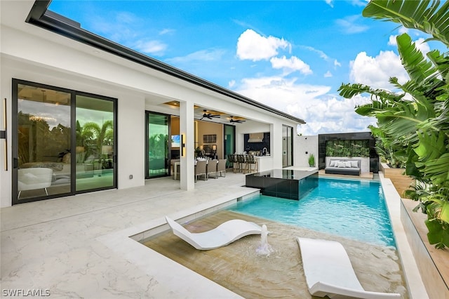 view of pool with a patio, outdoor lounge area, pool water feature, and ceiling fan