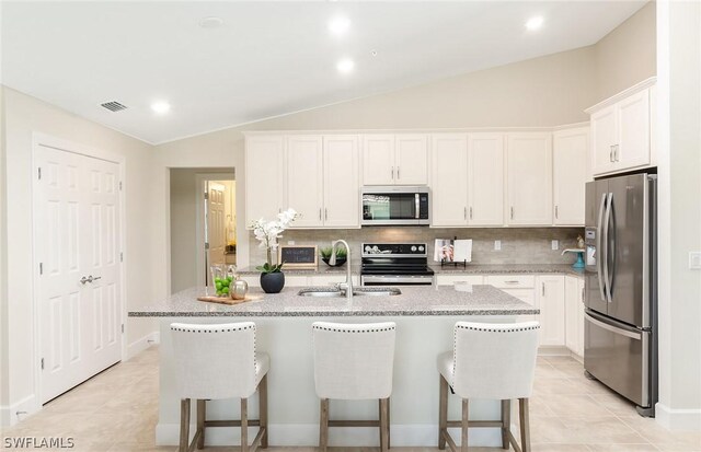 kitchen featuring an island with sink, white cabinetry, and appliances with stainless steel finishes