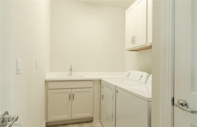 laundry area featuring sink, light tile patterned flooring, cabinets, and washing machine and clothes dryer