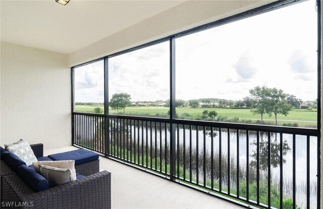 sunroom with a wealth of natural light and a water view