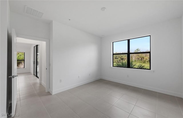 spare room with visible vents, baseboards, and light tile patterned floors