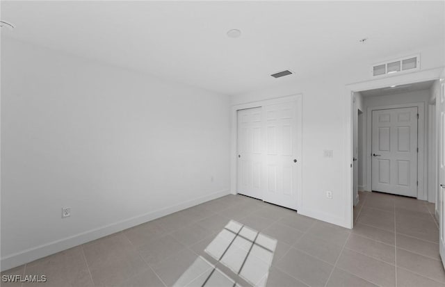 unfurnished bedroom featuring visible vents, baseboards, and light tile patterned floors