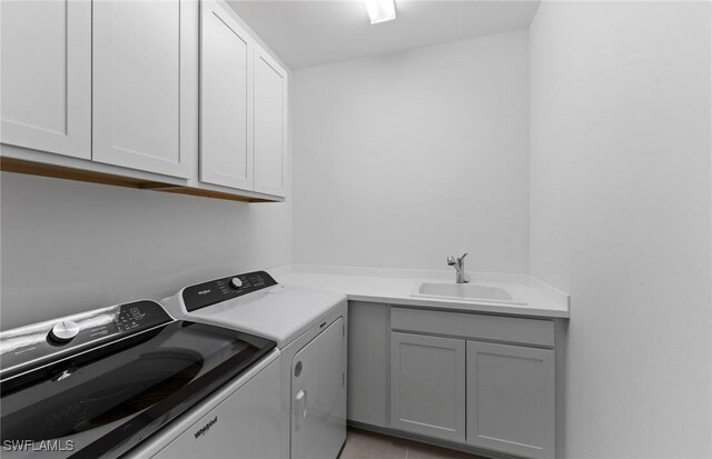 laundry room featuring cabinet space, a sink, and separate washer and dryer