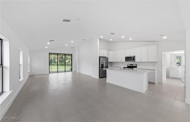 kitchen with stainless steel appliances, light countertops, visible vents, open floor plan, and white cabinets