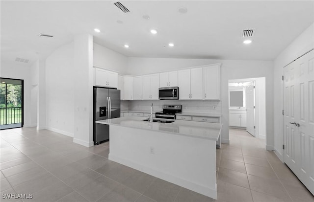 kitchen with visible vents, white cabinets, appliances with stainless steel finishes, a kitchen island with sink, and a sink