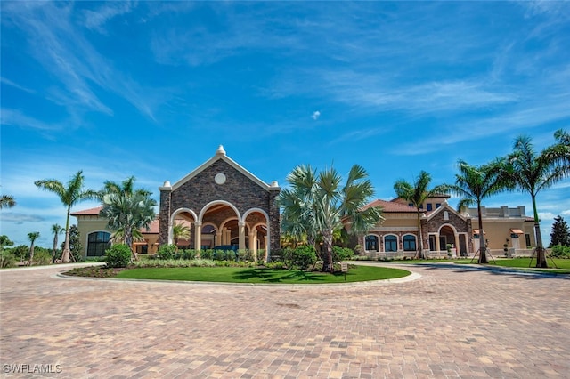 view of front of home with decorative driveway and a yard