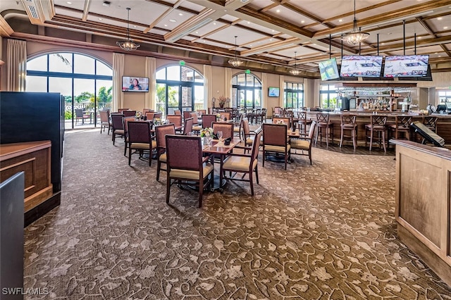 dining room featuring coffered ceiling, a towering ceiling, a bar, beamed ceiling, and crown molding