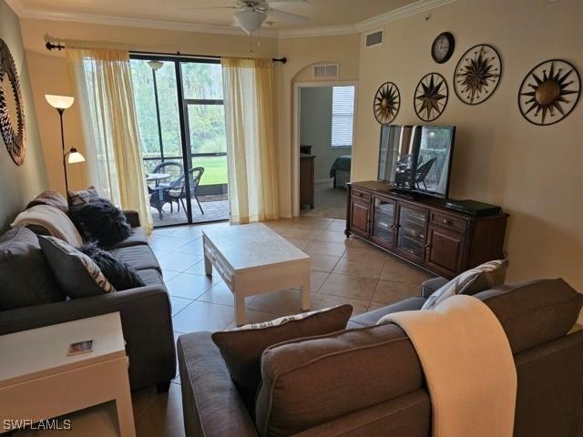 living area featuring ornamental molding, visible vents, ceiling fan, and light tile patterned floors