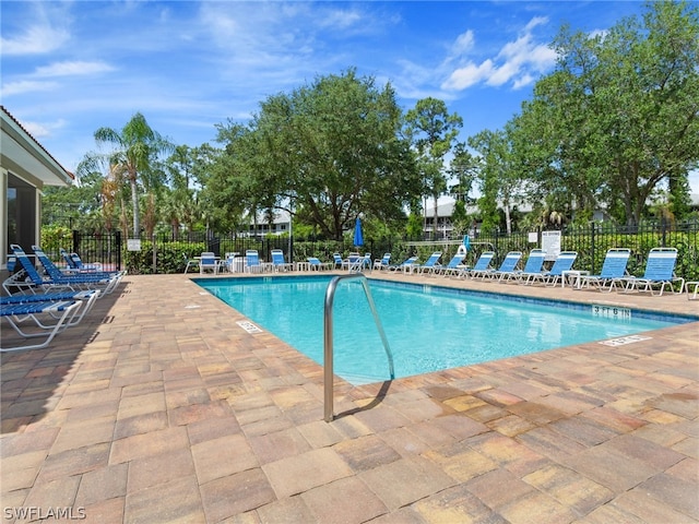 pool with fence and a patio