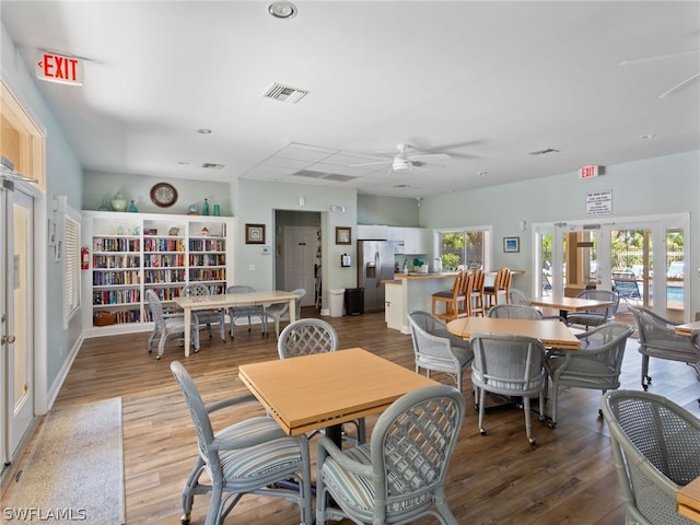 dining room with a healthy amount of sunlight, visible vents, french doors, and wood finished floors