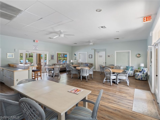 dining space with french doors, visible vents, ceiling fan, and light wood finished floors