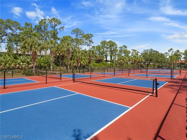 view of tennis court featuring community basketball court and fence