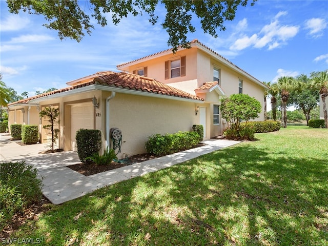 445 Robin Hood Cir Unit 202, Naples, FL 34104 - view of side of home with a yard, an attached garage, a tile roof, and stucco siding