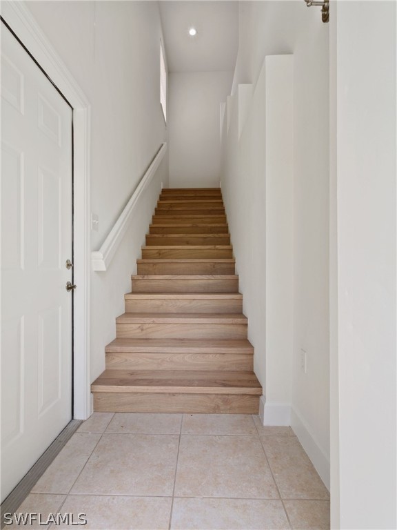 stairs with light tile patterned floors