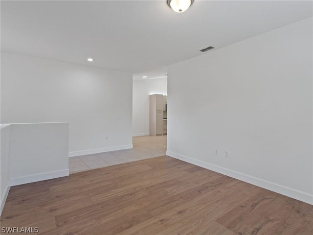 unfurnished room featuring light wood-style floors, baseboards, and visible vents