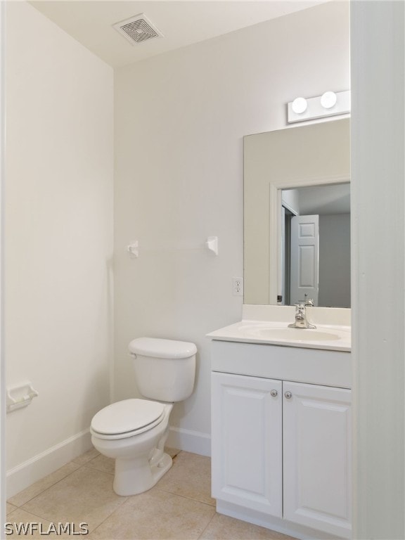 half bathroom with tile patterned flooring, visible vents, vanity, and baseboards