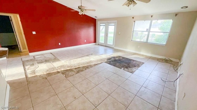 unfurnished room with ceiling fan, light tile patterned floors, lofted ceiling, and french doors