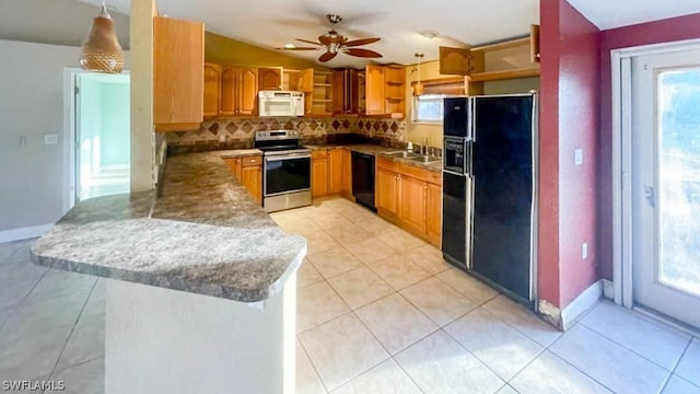 kitchen featuring kitchen peninsula, pendant lighting, sink, tasteful backsplash, and black appliances