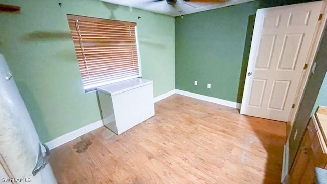 spare room with light wood-type flooring and ceiling fan