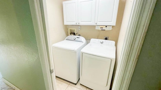 washroom featuring light tile patterned floors, cabinets, and washer and dryer