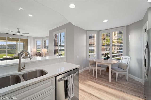 kitchen with light stone countertops, sink, plenty of natural light, and stainless steel appliances