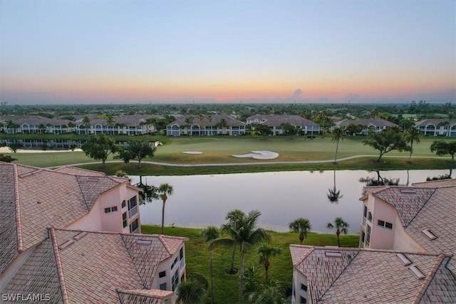 aerial view at dusk featuring a water view