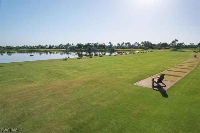 surrounding community featuring a lawn and a water view