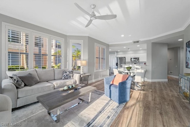 living room featuring ceiling fan, dark hardwood / wood-style floors, and crown molding