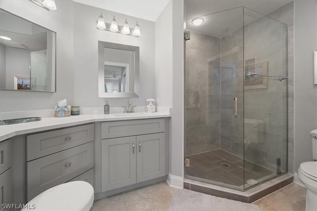 bathroom featuring toilet, vanity, an enclosed shower, and tile patterned flooring