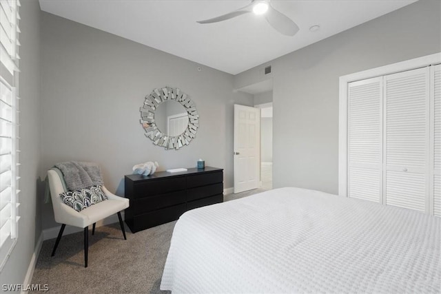 carpeted bedroom with a closet, ceiling fan, and multiple windows