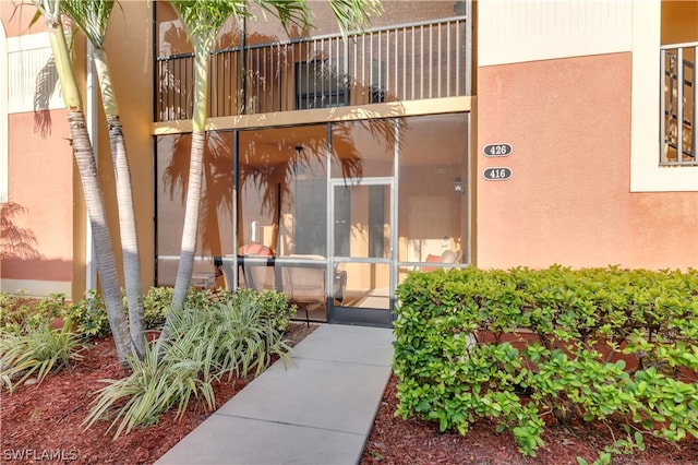 view of exterior entry with a balcony